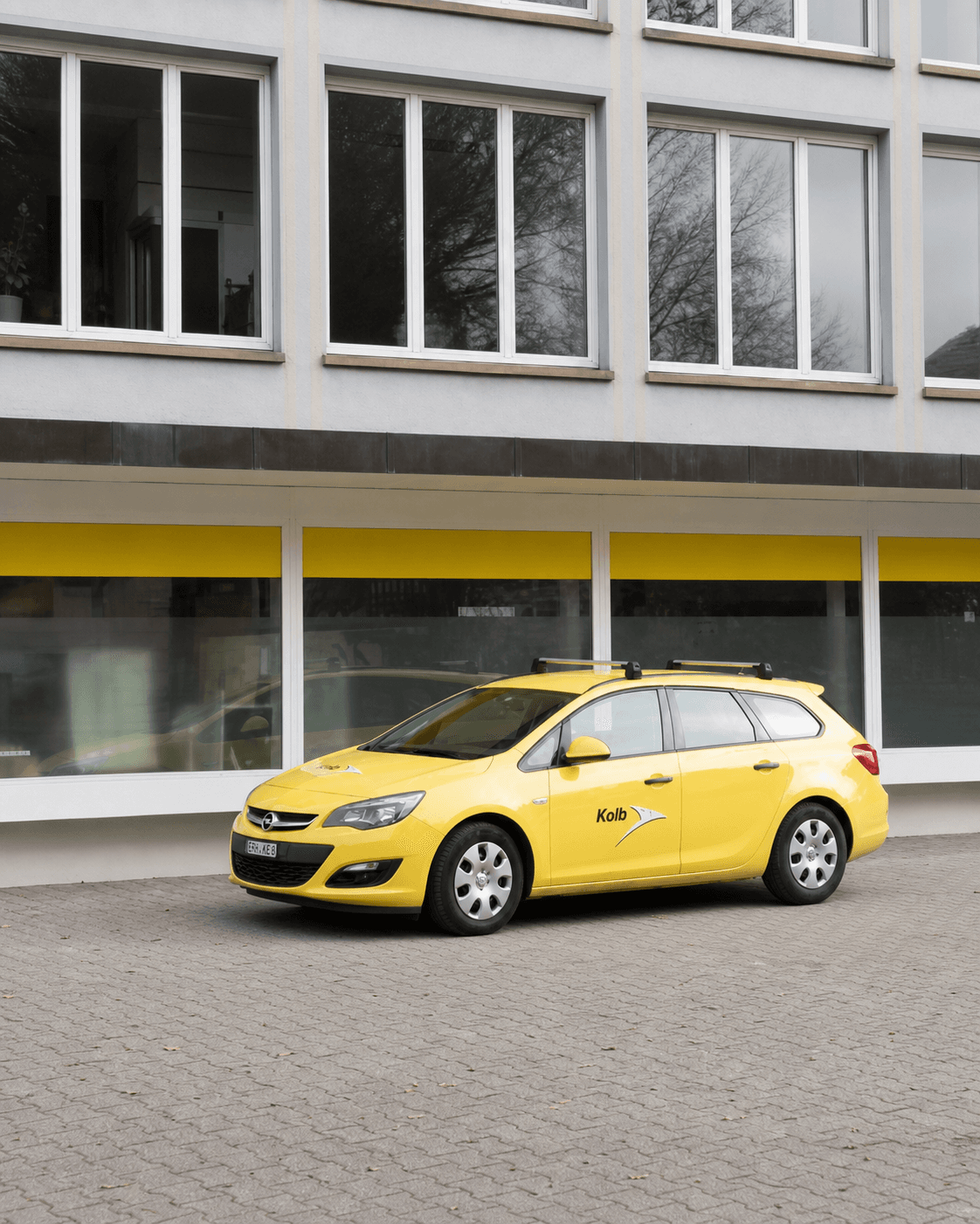 Gelbes Servicefahrzeug der Kolb Elektro SBW AG vor dem Firmengebäude